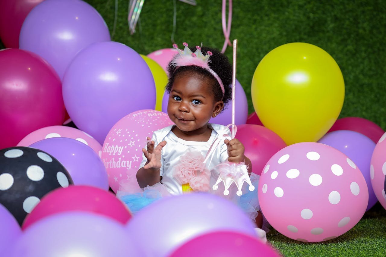 gallery-1 Cute child surrounded by colorful balloons enjoying a birthday party.