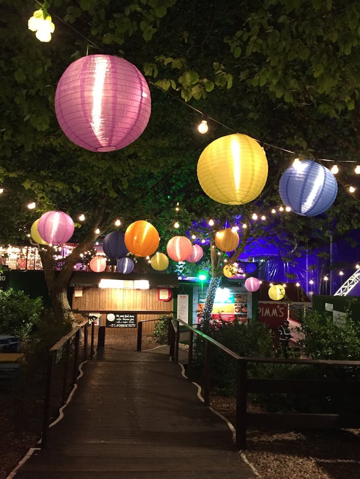 our-services-1 Vibrant paper lanterns hanging over a garden path during a festive night celebration outdoors.